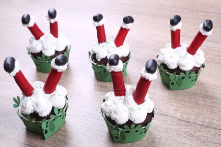 Foto de Un grupo de cupcakes decorados con azúcar de Santa Claus y abeto en el fondo de Navidad. - Imagen libre de derechos