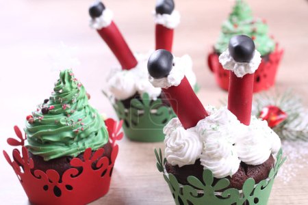 Téléchargez les photos : Un groupe de cupcakes décorés de sucre Père Noël et sapin sur le fond de Noël. - en image libre de droit