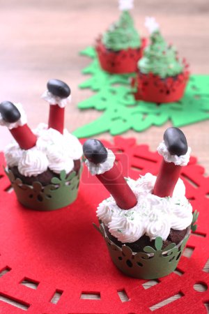 Foto de Un grupo de cupcakes decorados con azúcar de Santa Claus y abeto en el fondo de Navidad. - Imagen libre de derechos