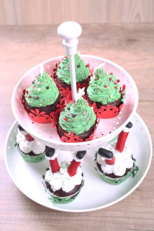 Téléchargez les photos : Un groupe de cupcakes décorés de sucre Père Noël et sapin sur le fond de Noël. - en image libre de droit