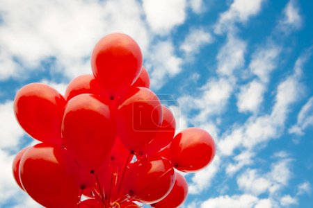 Téléchargez les photos : Bande de ballons rouges sur un ciel bleu - en image libre de droit