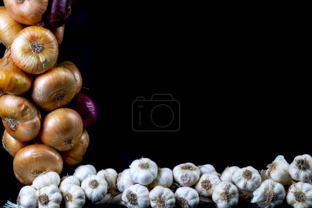 Foto de Dulce morado cebollas de Crimea, cebollas y ajo sobre fondo negro - Imagen libre de derechos