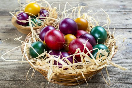 Téléchargez les photos : Œufs de Pâques dans le nid sur fond de bois rustique - en image libre de droit