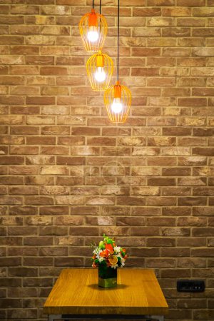 Téléchargez les photos : Gros plan de trois ampoules allumées sur fond mural en brique marron - en image libre de droit