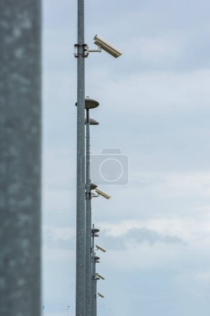 Téléchargez les photos : Caméras de sécurité sur un poteau sur fond de ciel clair - en image libre de droit