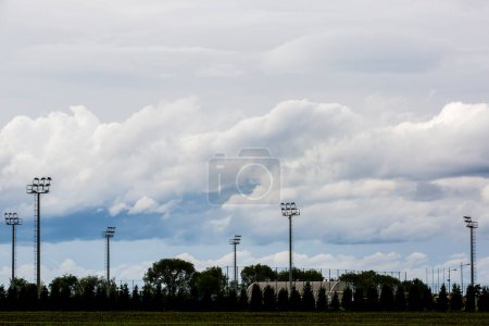 Téléchargez les photos : Un nuage de pluie au-dessus du stade avec projecteurs - en image libre de droit