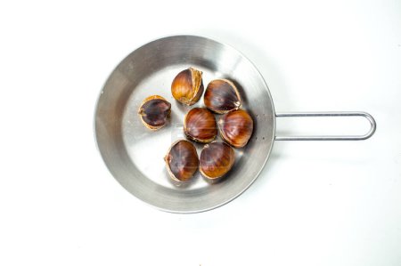 Téléchargez les photos : Marrons rôtis dans une casserole sur fond blanc - en image libre de droit