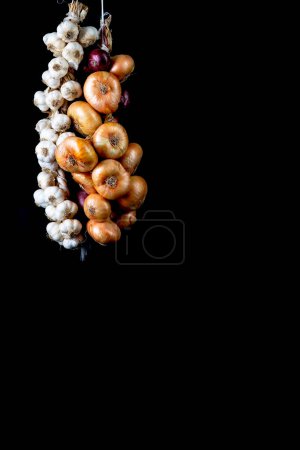 Foto de Dulce morado cebollas de Crimea y ajo sobre fondo negro - Imagen libre de derechos
