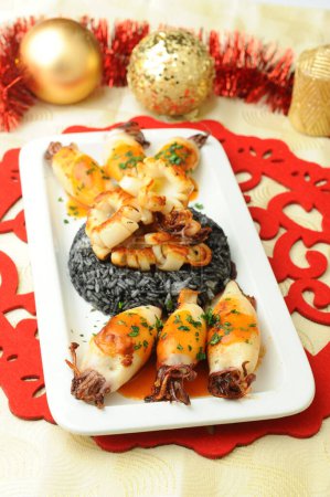 Photo for Squids and black risotto on plate - Royalty Free Image