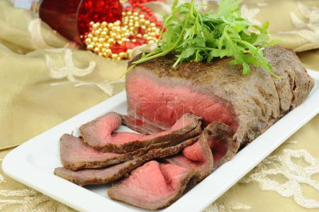 Téléchargez les photos : Steak de bœuf grillé rare tranché avec des feuilles de roquette - en image libre de droit