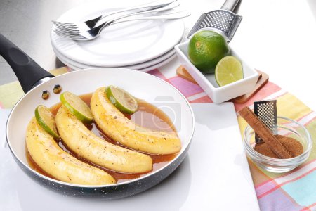 Téléchargez les photos : Bananes caramélisées dans une casserole en aluminium avec crème glacée - en image libre de droit