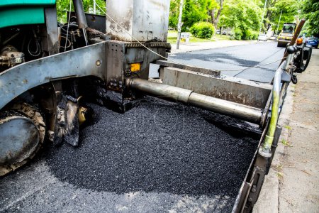 Foto de Camión de pavimento industrial que pone asfalto fresco en el sitio de construcción - Imagen libre de derechos