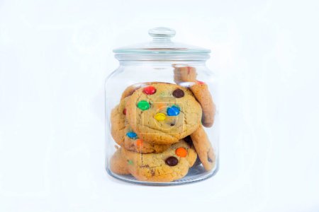 Photo for Cookies with colored candies in a glass jar on a white background - Royalty Free Image