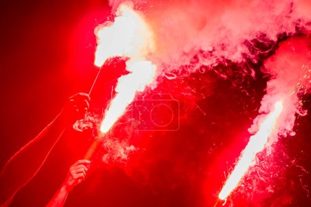 Foto de Aficionados al fútbol están sosteniendo antorchas en el fuego durante un partido - Imagen libre de derechos