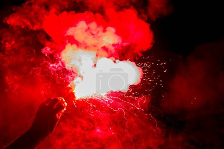 Photo for Football fans are holding torches in fire during a match - Royalty Free Image