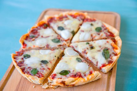 Foto de Pizza con aceite de oliva y tomates sobre fondo azul, Vista superior - Imagen libre de derechos