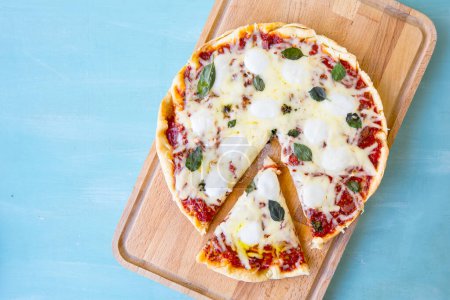 Téléchargez les photos : Pizza à l'huile d'olive et tomates sur fond bleu, vue sur le dessus - en image libre de droit