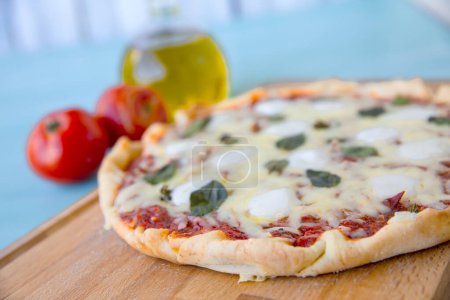 Photo for Pizza with olive oil and tomatoes on a blue background, Top view - Royalty Free Image