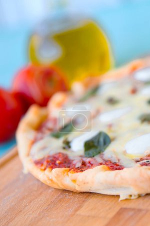 Photo for Pizza with olive oil and tomatoes on a blue background, Top view - Royalty Free Image