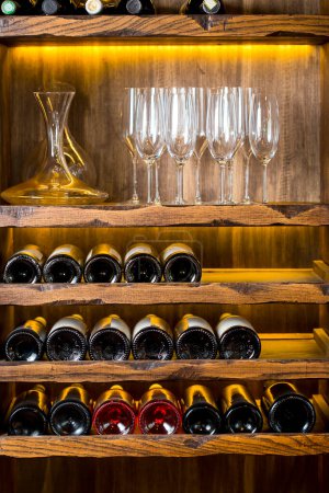 Photo for Wine bottles on wooden shelves - Royalty Free Image