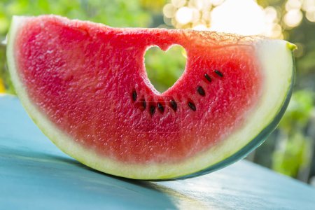 Photo for Watermelon with a heart symbol at sunset - Royalty Free Image