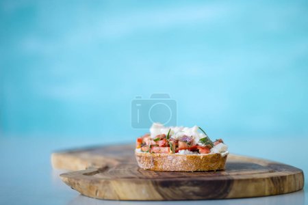 Téléchargez les photos : Brosse à la tomate, au fromage et à l'huile d'olive sur fond bleu - en image libre de droit