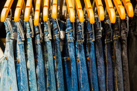 Photo for Jeans trousers on hangers in a shop - Royalty Free Image