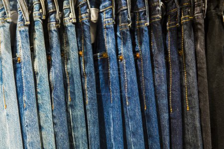 Photo for Jeans trousers on hangers in a shop - Royalty Free Image