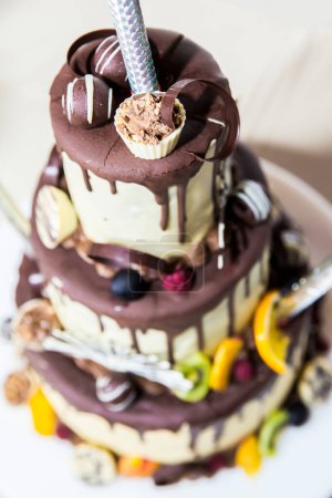 Photo for Beautiful three-tiered cake on plate - Royalty Free Image