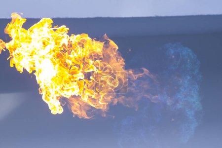 Téléchargez les photos : Flamme de feu sur fond bleu - en image libre de droit