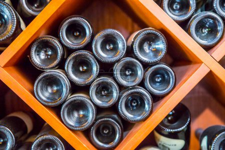 Photo for Bottles of red wine on the shelves - Royalty Free Image