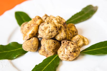 Photo for Delicious truffles with leaves on plate - Royalty Free Image