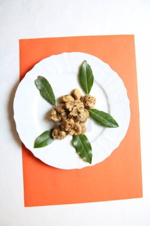 Photo for Delicious truffles with leaves on plate - Royalty Free Image
