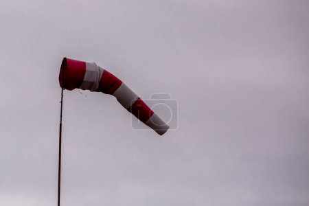 Téléchargez les photos : Girouette rouge et blanche sur fond nuageux - en image libre de droit
