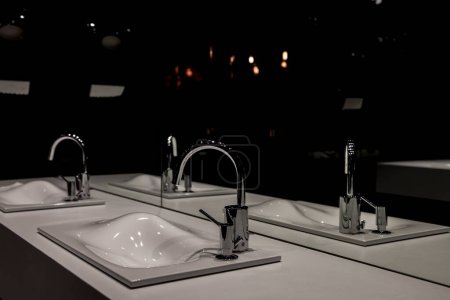 Foto de Grifo de cromo con lavabo y moderno baño negro - Imagen libre de derechos