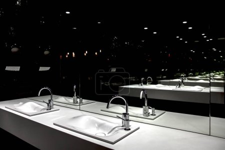 Foto de Grifo de cromo con lavabo y moderno baño negro - Imagen libre de derechos