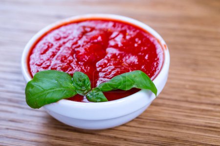 Photo for Tomato sauce with fresh basil on a wooden background - Royalty Free Image