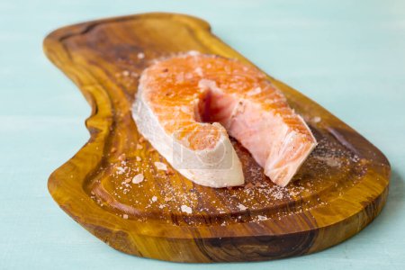 Téléchargez les photos : Poisson de saumon sur une planche de bois sur fond bleu - en image libre de droit