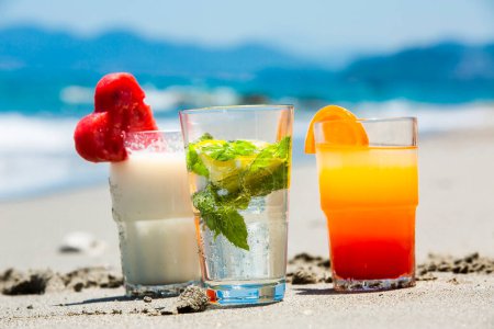 Photo for Summer cocktails with a blur beach in the background - Royalty Free Image