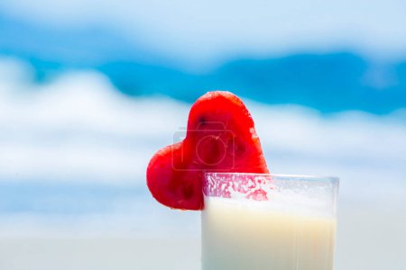 Foto de Cóctel de verano pinacolada con sandía en la playa en borroso - Imagen libre de derechos