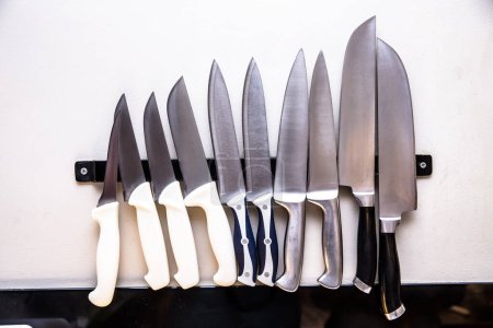 Foto de Varios tipos de cuchillos de cocina en soporte magnético - Imagen libre de derechos