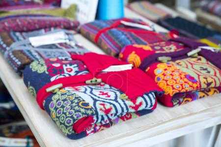 Foto de Varios suéteres coloridos de la ropa caliente de punto en el mercado. - Imagen libre de derechos