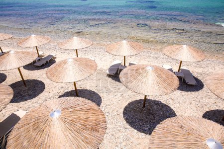 Foto de Sombrillas de paja de playa y sol en la playa - Imagen libre de derechos