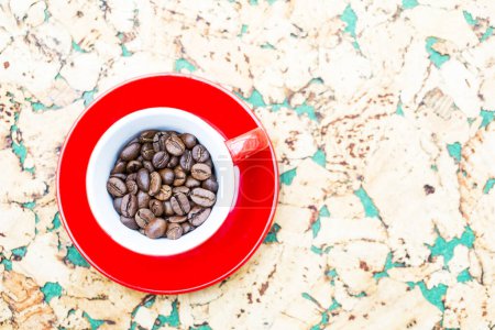 Téléchargez les photos : Grains de café dans une tasse rouge sur un fond vert blanc - en image libre de droit