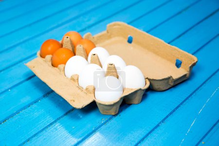 Téléchargez les photos : Vue de la boîte ouverte d'œufs de poulet, fond bleu - en image libre de droit