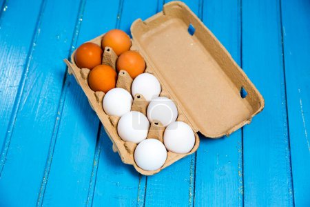 Foto de Vista de la caja abierta de huevos de pollo, fondo azul - Imagen libre de derechos