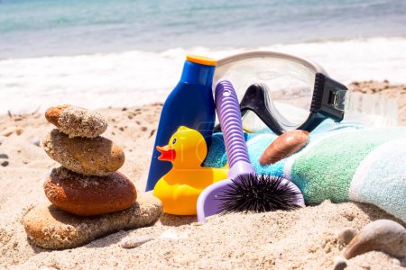 Téléchargez les photos : Crème solaire, serviettes et masques de plongée sur la plage - en image libre de droit