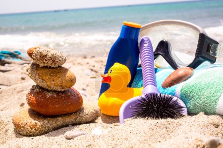 Téléchargez les photos : Crème solaire, serviettes et masques de plongée sur la plage - en image libre de droit