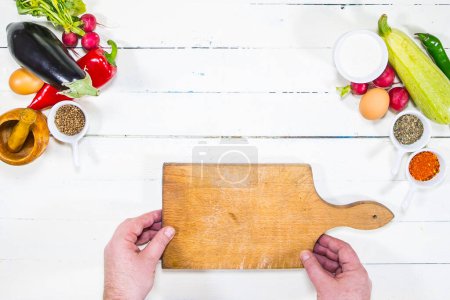Photo for Hands cutting fresh vegetables on a wooden table - Royalty Free Image