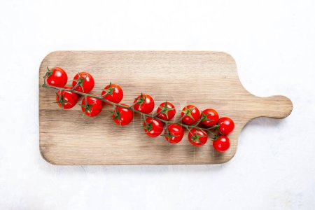Téléchargez les photos : Tomates cerises sur une planche de bois - en image libre de droit